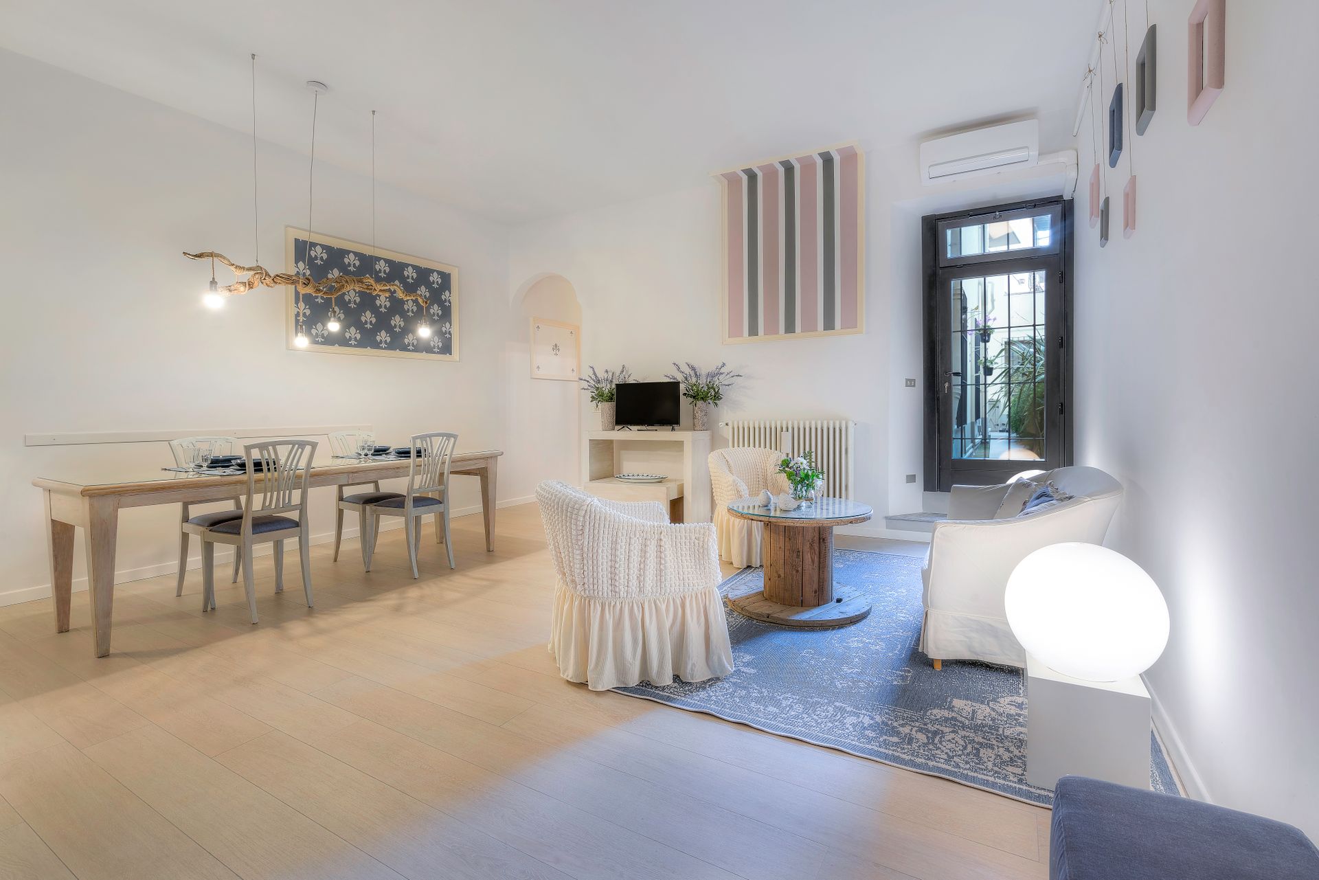 Illustrative bright shared living and dining room with a long timber table